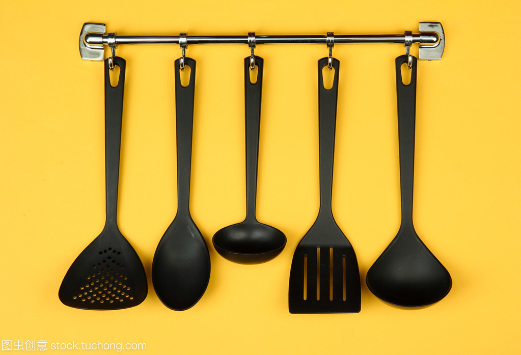 银钩,在黄色背景上的黑色厨房用具